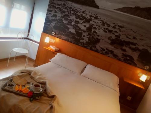 Un dormitorio con una cama con una tabla. en Hotel Dabeleira, en Luarca