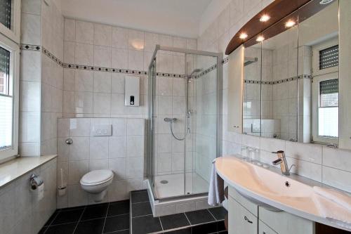 a bathroom with a shower and a sink and a toilet at Hotel Jammerkrug in Gladbeck