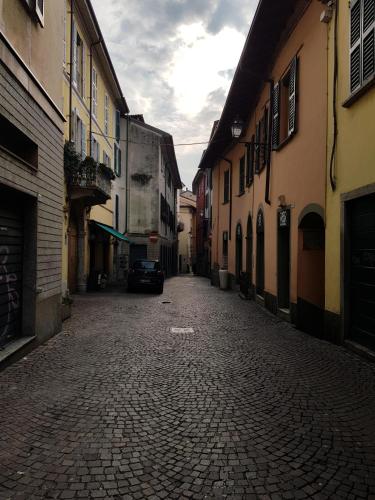 an alley with buildings and a car on a street at Le Casette Di Osvaldo in Lecco