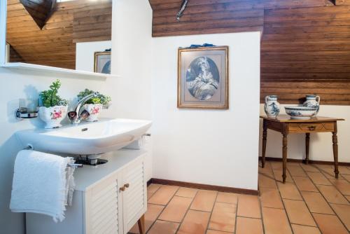 a bathroom with a sink and a wooden ceiling at Charming and cosy apartment near Lucerne in Römerswil
