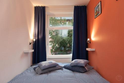 a bedroom with a bed with pillows in front of a window at B&B West City Amsterdam in Amsterdam