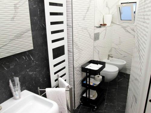 a black and white bathroom with a sink and a toilet at Minihouse in Bari