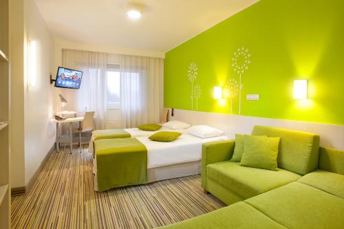 a hotel room with two beds and a couch at Tallink Express Hotel in Tallinn