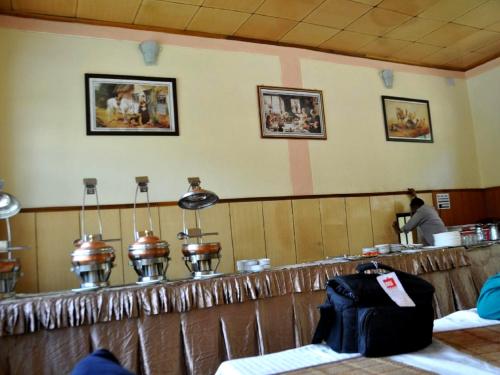 een bar in een restaurant met een persoon die eten bereidt bij Hotel Abu Palace in Leh