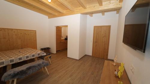 a room with a bed and a table and a tv at Apartment Hanna in Ramsau im Zillertal