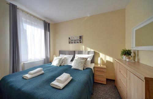 カルパチにあるApartamenty Sun Seasons 24 - Karpacz Centrumのベッドルーム1室(ブルーベッド1台、タオル2枚付)