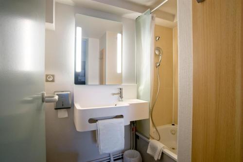 La salle de bains blanche est pourvue d'un lavabo et de toilettes. dans l'établissement B&B HOTEL Moulins, à Toulon-sur-Allier