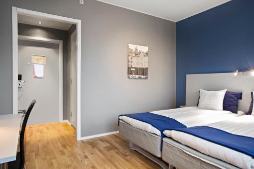 a bedroom with a bed with a blue accent wall at Sure Hotel by Best Western Stockholm Alvsjo in Stockholm