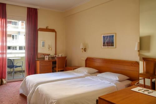 a hotel room with two beds and a desk at Congo Palace in Athens