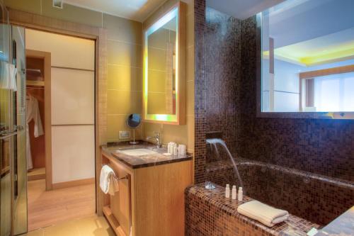 a bathroom with a tub and a sink and a shower at Marina Place Resort in Genoa