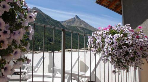 a balcony with flowers and a view of a mountain at Residence Au Vieux Grenier in Cogne