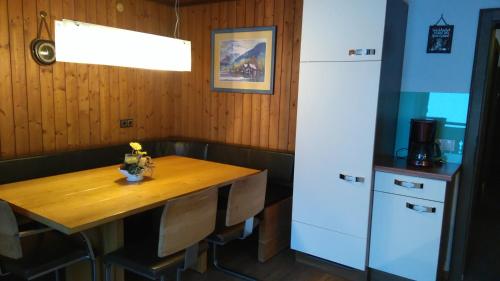 a kitchen with a wooden table and a refrigerator at Hinterlammerain in Abtenau