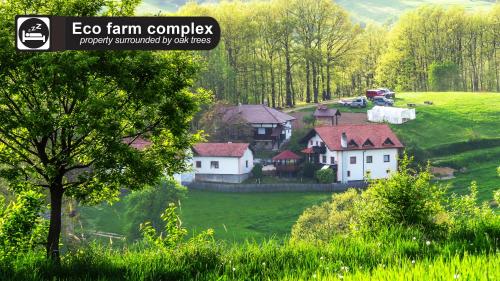 un groupe de maisons sur une colline verdoyante plantée d'arbres dans l'établissement Eco Farm Milanovic, à Despotovac