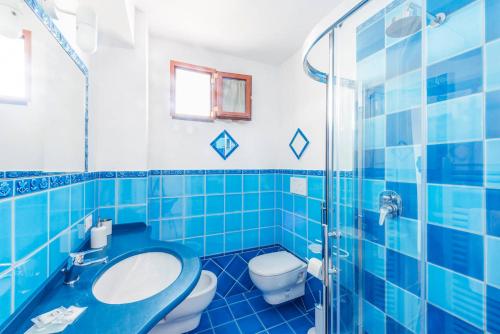 een blauw betegelde badkamer met een toilet en een wastafel bij Casa Satriano in Positano