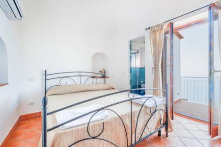 een slaapkamer met een bed in een kamer met een raam bij Casa Satriano in Positano