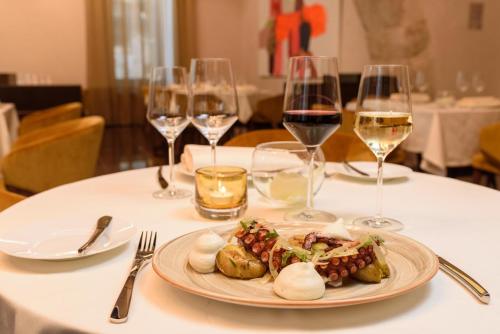 a plate of food on a table with wine glasses at Áurea Museum by Eurostars Hotel Company in Lisbon