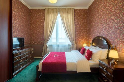 モスクワにあるLux-Apartments Смоленский бульвар, 7のベッドとテレビが備わるホテルルームです。