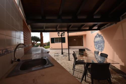 a kitchen with a sink and a glass table at Villa Chaves in Funchal
