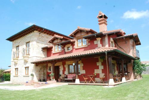 a large brick house with a chimney on top at Posada La Fabula in Santillana del Mar