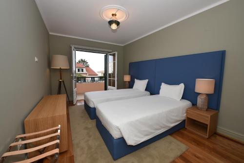 a bedroom with a large bed with a blue headboard at Villa Chaves in Funchal