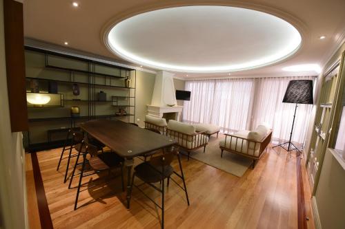 a living room with a table and chairs and a room with a piano at Villa Chaves in Funchal