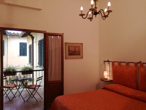 a bedroom with a bed and a balcony with a table at Dimora Pieri in Florence