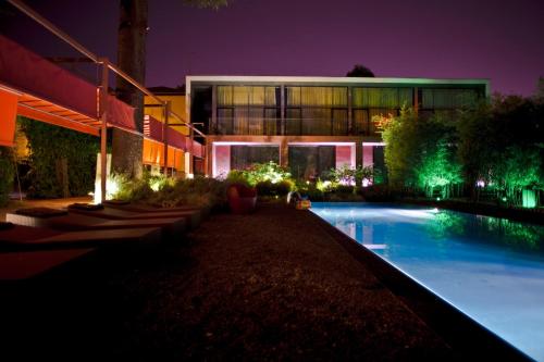 a building with a swimming pool at night at Hotel Clocchiatti Next in Udine