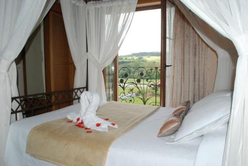 a bedroom with a bed with a large window at Posada La Fabula in Santillana del Mar