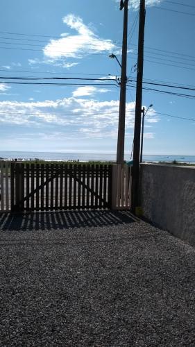 a wooden fence next to a wall with a pole at Meu pequeno paraíso in Itapoa