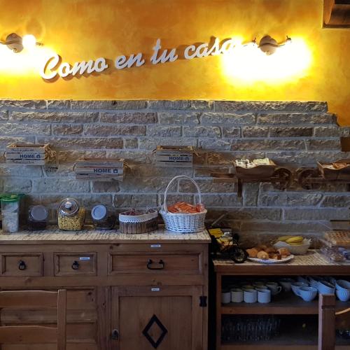 a sign that says come in in awhile on a brick wall at Posada La Fabula in Santillana del Mar
