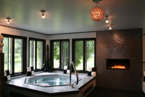a large bathroom with a tub and a fireplace at The Roxbury in Roxbury