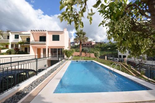 a swimming pool in front of a house at Villa Chaves in Funchal