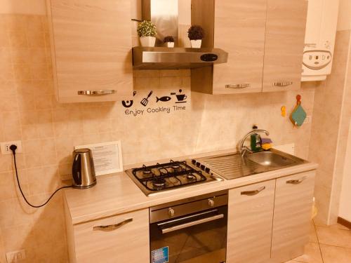 uma pequena cozinha com um fogão e um lavatório em Aduepassidallafiera em Bolonha
