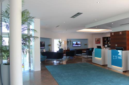 an office with a lobby with tables and chairs at OPOHOTEL Porto Aeroporto in Maia
