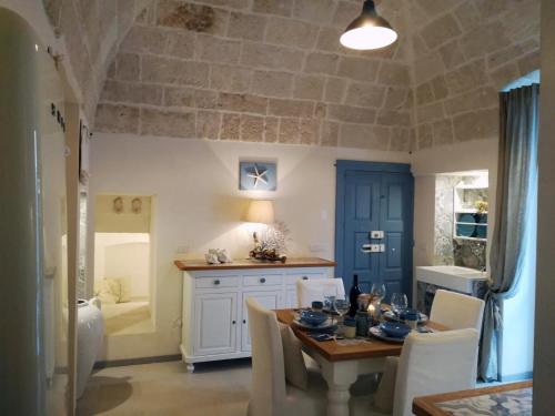 a dining room with a table and chairs and a kitchen at Casa Carlotta in Monopoli