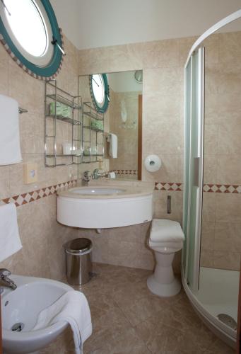 a bathroom with a tub and a sink and a toilet at Hotel Gaby in Rimini