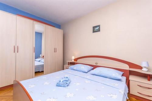 Un dormitorio con una cama con almohadas azules. en Apartments Albina, en Brodarica