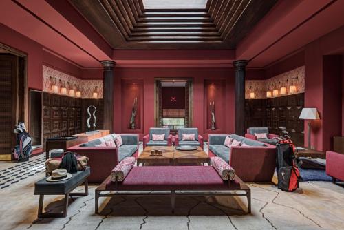 a living room with red walls and couches at Fairmont Royal Palm Marrakech in Marrakech