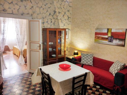 salon ze stołem i czerwoną kanapą w obiekcie Appartamento Piazza Vittorio Trapani w Trapani