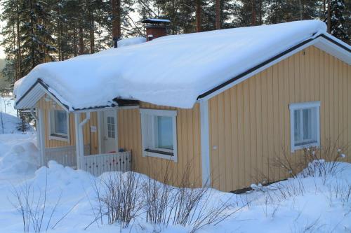 a house with snow on the roof of it at Lake Cottage Jänisvaara in Kolinkylä