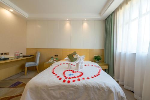 a bed with a heart made out of roses at Dunhuang Hotel in Dunhuang