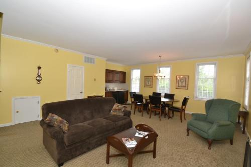 a living room with a couch and chairs and a table at Century Suites Hotel in Bloomington