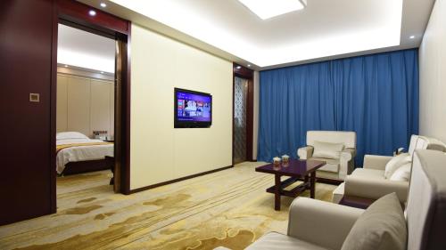 a hotel room with a tv and a bedroom at Dunhuang Hotel in Dunhuang