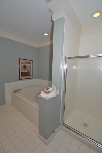 a bathroom with a shower and a bath tub at Century Suites Hotel in Bloomington