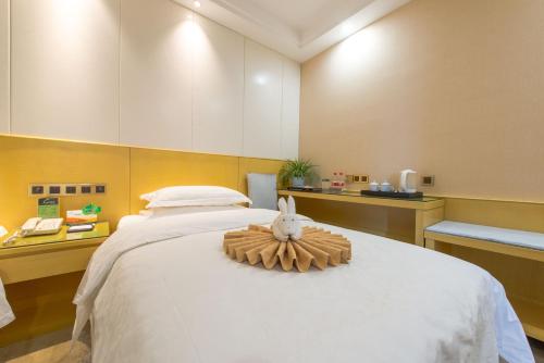 a bedroom with a bed with a toy rabbit on it at Dunhuang Hotel in Dunhuang