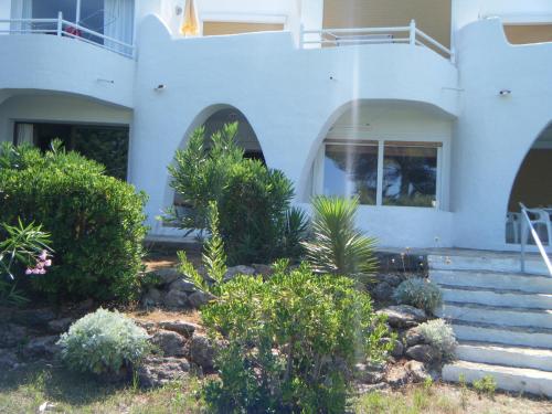 a white house with stairs and plants in front of it at Siesta Mar Apartamentos Ibiza in Santa Eularia des Riu