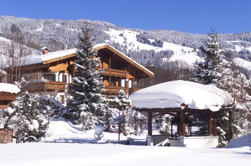 a log cabin in the snow with snow at Altachhof Hotel und Ferienanlage - Jokercard im Sommer inklusive in Saalbach Hinterglemm