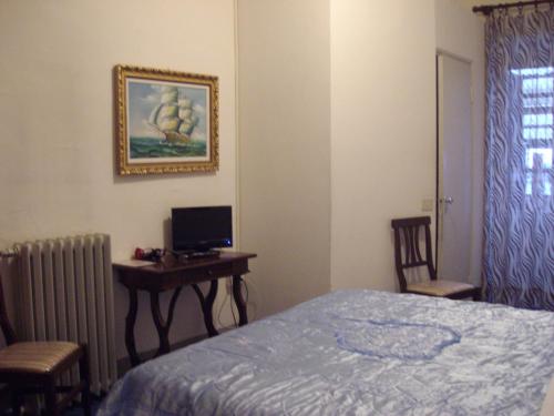 a bedroom with a bed and a desk with a computer at Albergo Anna in Perugia
