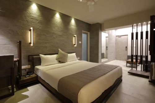a bedroom with a large bed in a room at Hotel Carrefour in Ahmedabad