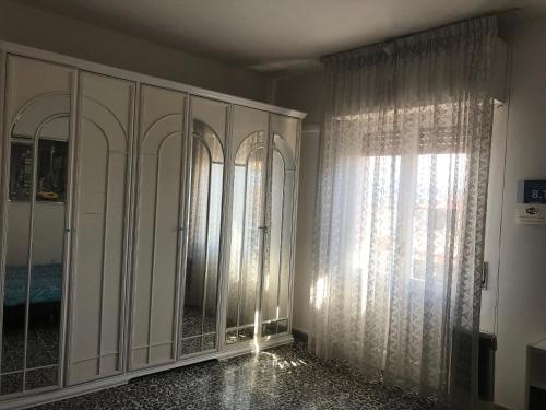 a room with white cabinets and a window at B&B Cagliari Ariosto in Cagliari